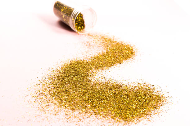istock A track of scattered gold spangles on a pink background. 1057830294