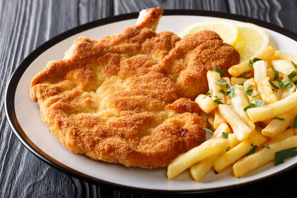 cielęć alla milanese w bułce tartej z cytryną i frytkami z bliska na talerzu. poziomy - cutlet schnitzel french fries scaloppini zdjęcia i obrazy z banku zdjęć