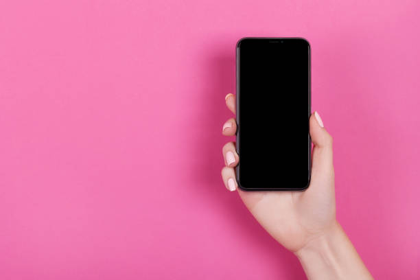 istock Top view of a woman hand using phone on pink background. 1057832624
