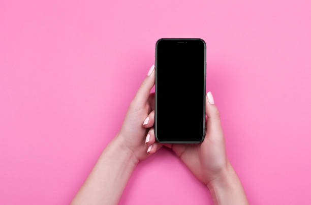 istock Top view of a woman hand using phone on pink background. 1057832646