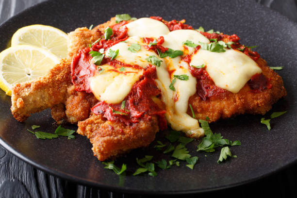 milanesa a la napolitana beef cutlet breaded with mozzarella cheese and tomato sauce closeup. horizontal - milanese imagens e fotografias de stock