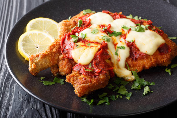 la milanesa napolitana - tritata di carne di frutta fatta in casa con mozzarella, limone e salsa di pomodoro da vicino. orizzontale - schnitzel cutlet food meal foto e immagini stock