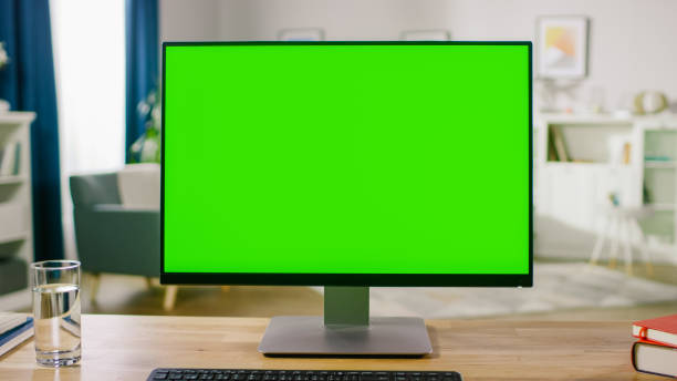 istock Personal Computer with Mock-up Green Screen Display Standing on the Desk in the Cozy Home Office Living Room of Prominent Designer. 1057833322