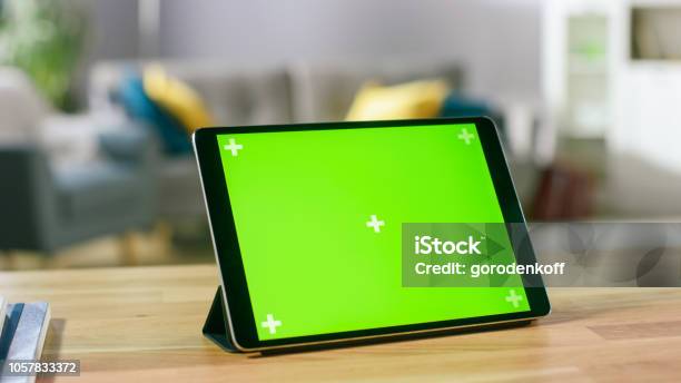 Moving Shot Of The Green Mockup Screen Digital Tablet Computer Standing On A Desk In Landscape Mode In The Background Depth Of Field Cozy Living Room Stock Photo - Download Image Now