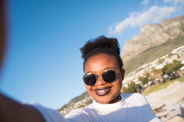 istock African woman taking a selfie on the beach 1057835662