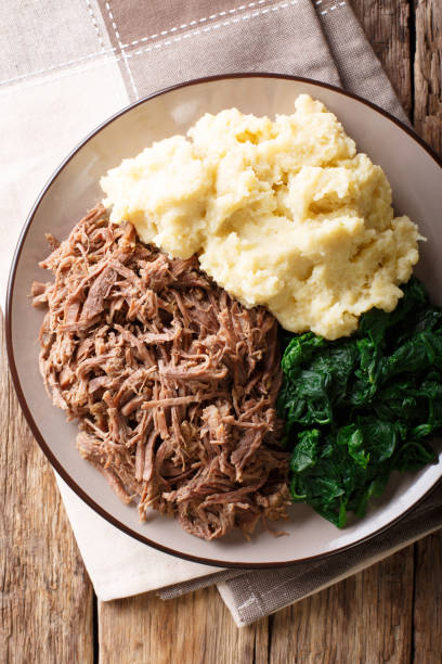istock Botswana food - Seswaa stewed beef with Sadza from corn flour and spinach, close-up. Vertical top view 1057835876