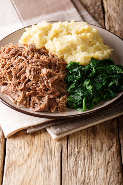 istock Botswana national dish - Seswaa stewed meat with Sadza from corn flour and spinach, close-up on a plate. vertical 1057835908