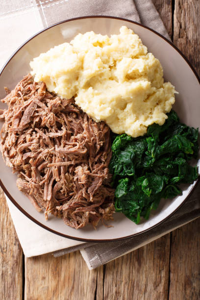 istock South African food: - Seswaa shredded beef with sadza porridge and spinach close-up on a plate. Vertical top view 1057836270