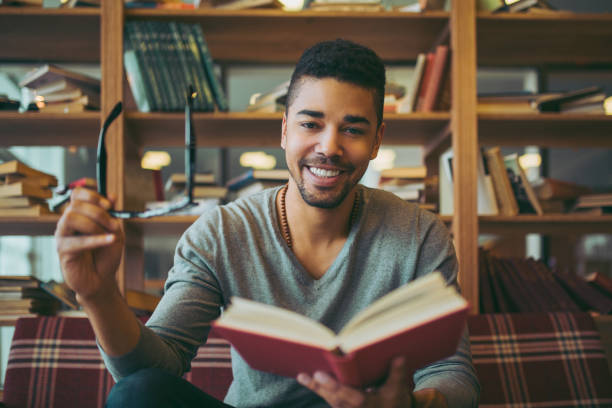 istock Smiling African American student enjoying book reading in library 1057838168