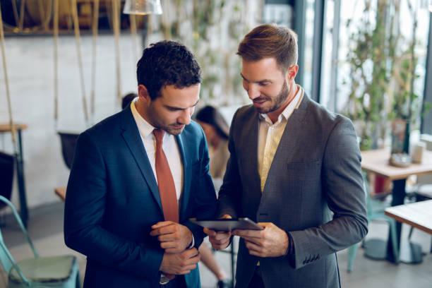 istock Two young businessmen discussing business strategy using digital tablet 1057838788