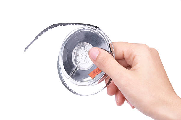 istock Old film reel in hand isolated on white. 105784055