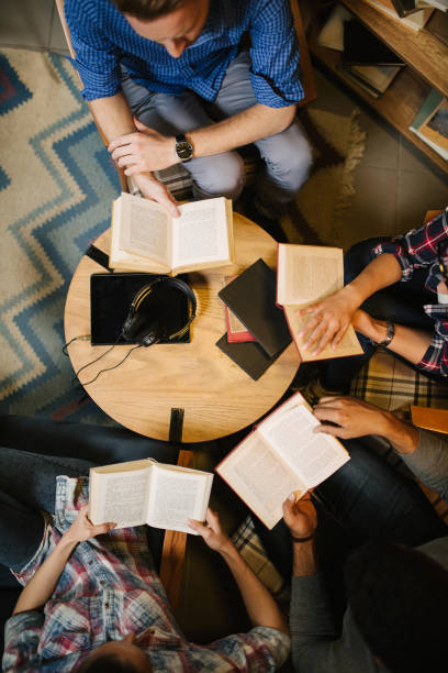 istock Diverse group of friends discussing a book in library 1057843594