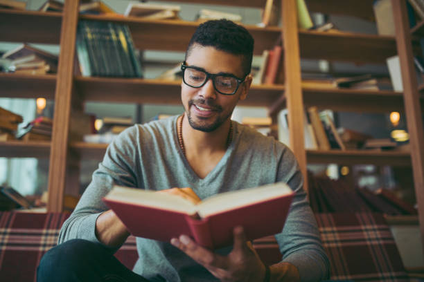 istock Smiling African American student enjoying book reading in library 1057844050
