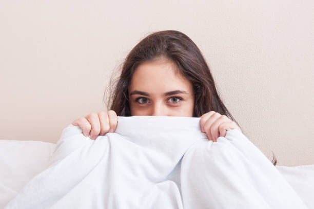 istock girl hides behind a blanket 1057844674