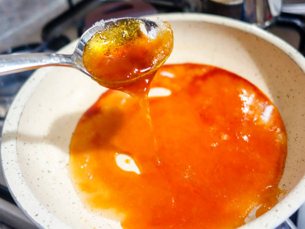 istock Caramel Sauce bubbles and is stirred on a stove. 1057844868
