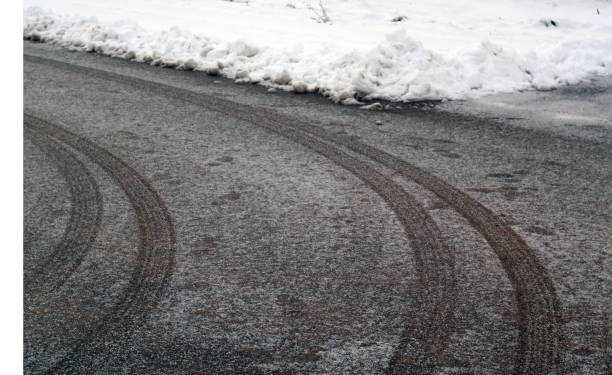 istock Car tyre prints on frosty road. 1057857512