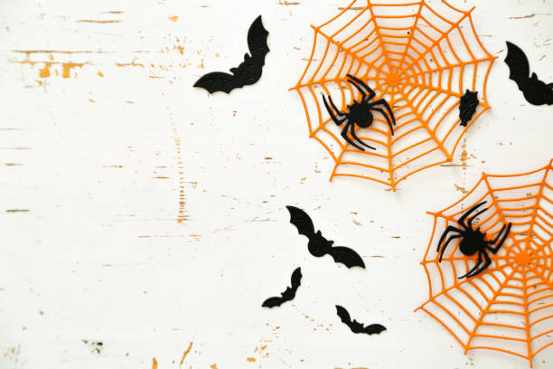 istock Halloween concept - spiders, bats, web paper crafts on bright background 1057860514