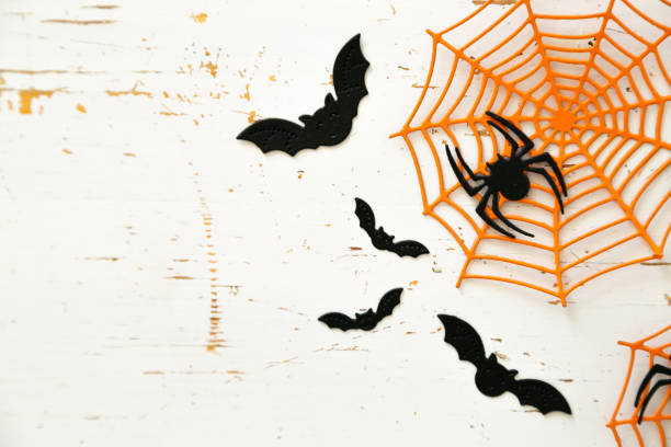 istock Halloween concept - spiders, bats, web paper crafts on bright background 1057860528