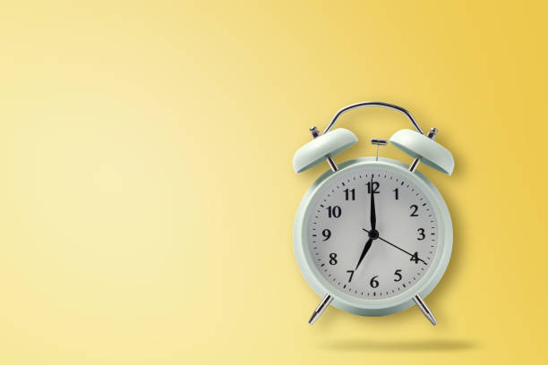 istock retro alarm clock on yellow background, pastel alarm clock with clipping path 1057862384