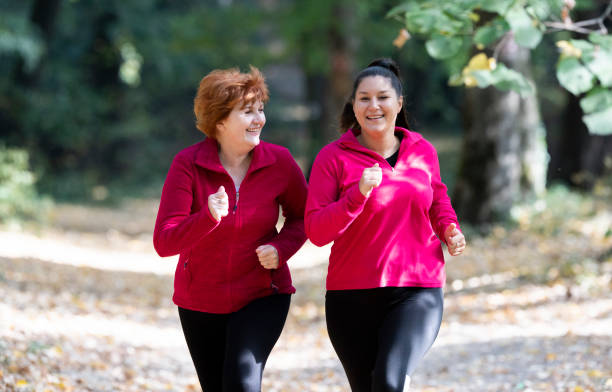 スポーツ ウエアを着ていると山で森で実行されている母と娘 - active seniors women senior adult mature adult ストックフォトと画像