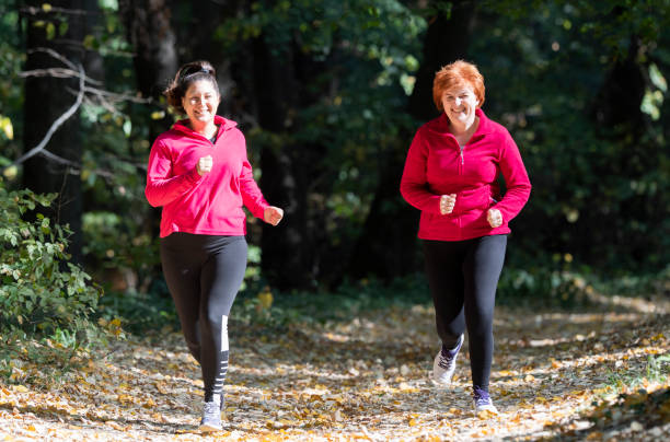 スポーツ ウエアを着ていると山で森で実行されている母と娘 - active seniors women senior adult mature adult ストックフォ��トと画像