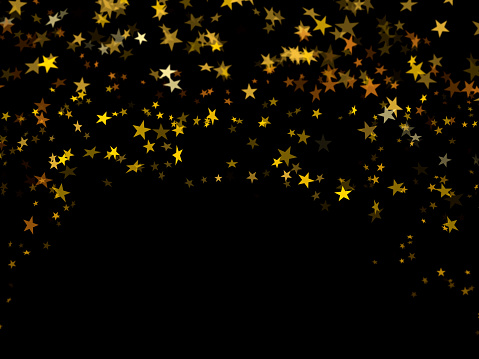Falling golden confetti stars on black background