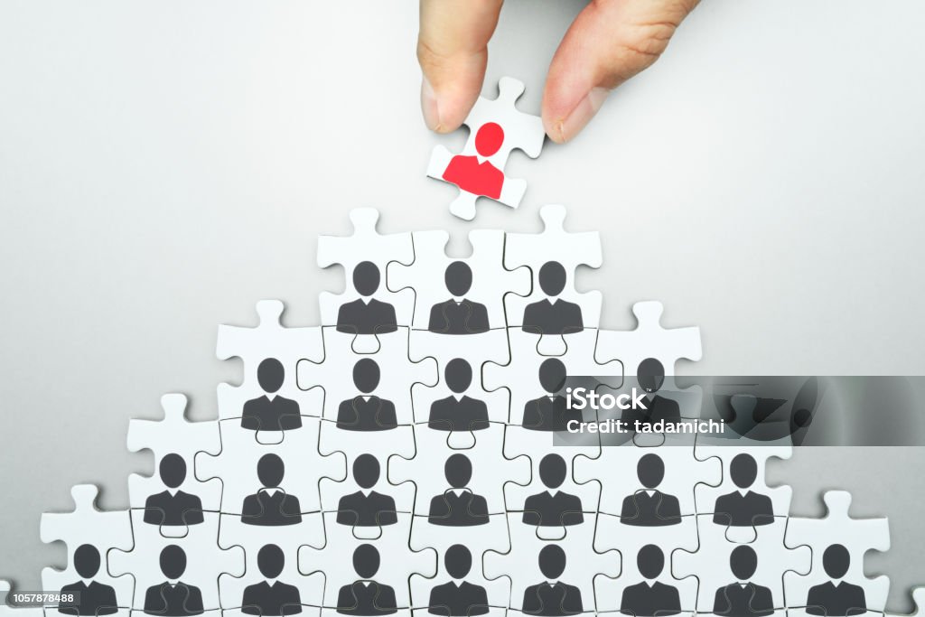 Selecting leader of business organization. Human resource management. Head hunting. Assembling jigsaw puzzle. Organizing business people hierarchy. CEO Stock Photo