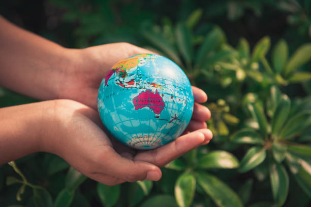 Save the earth concept, Woman hands is holding mockup the global on tree leave background Save the earth concept, Woman hands is holding mockup the global on tree leave background. australasia stock pictures, royalty-free photos & images