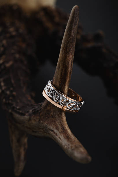 istock Pink gold and white gold ring with floral pattern on black background 1057881284