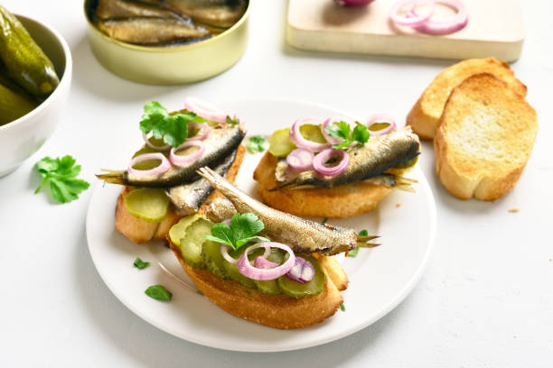 istock Sandwiches with sprats, marinated cucumber and onion 1057881472