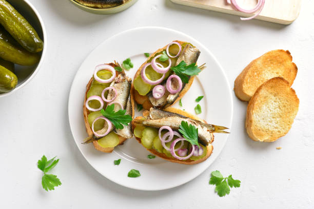 istock Sandwiches with sprats, marinated cucumber and onion 1057881488
