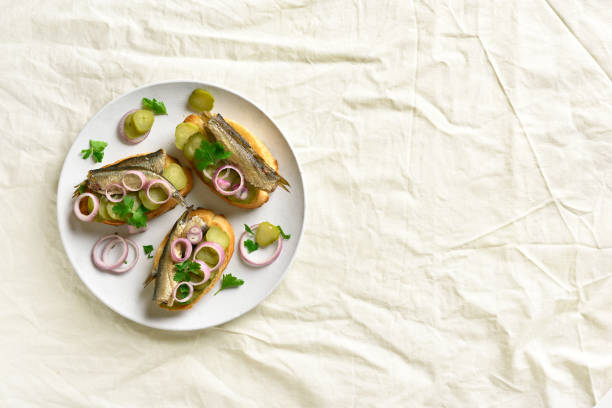 istock Sandwiches with sprats, marinated cucumber and onion 1057881584