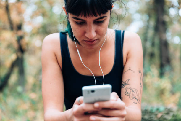istock Fit young woman with smartphone in forest 1057886016