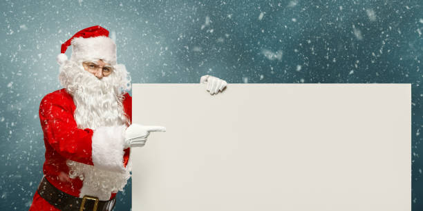 istock Happy Santa Claus points to a blank banner with to copy space. 1057892606