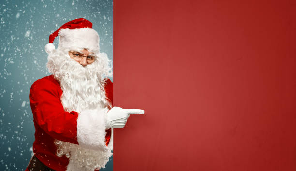 istock Happy Santa Claus points to a blank banner with to copy space. 1057892622
