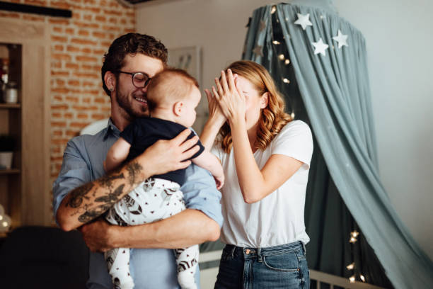Parents playing hide and seek with their baby boy