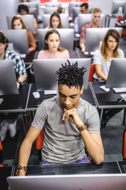 istock Above view of black student and his classmates on a computer class. 1057898836