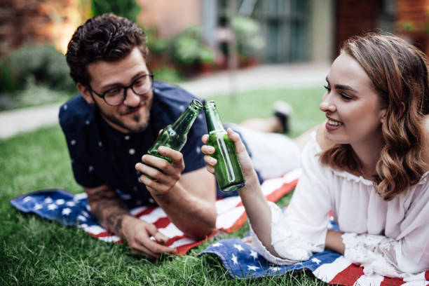 istock Young couple having beer in a park 1057899602