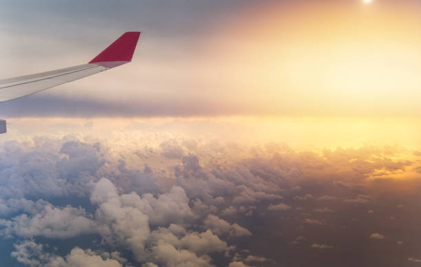 istock Wing of an airplane flying above the clouds with blue sky. 1057906986