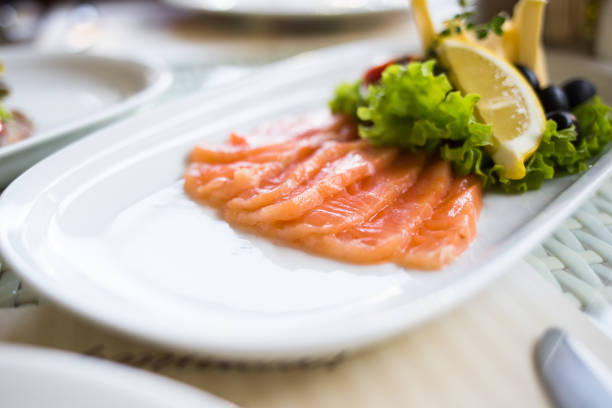 istock sliced smoked salmon served with lemon slices on white plate 1057912408