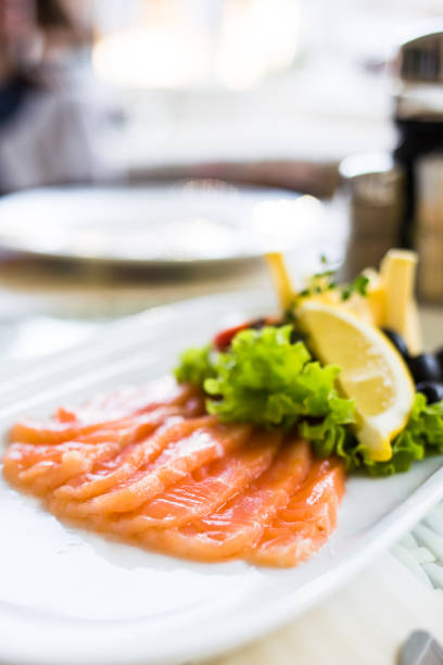 istock sliced smoked salmon served with lemon slices on white plate 1057912486