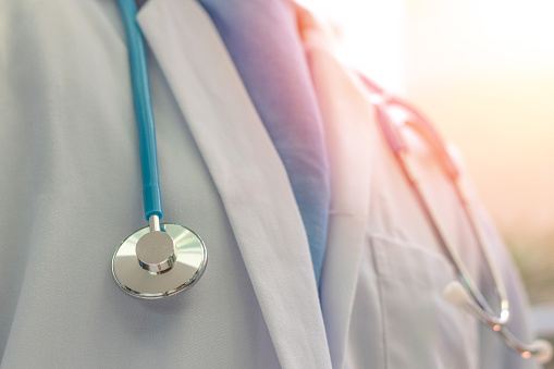 Doctor en medicina o médico en blanco vestido de uniforme con estetoscopio en hospital o clínica photo
