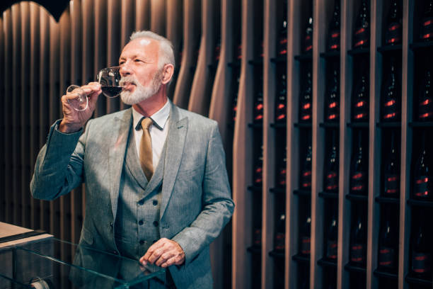 歳の男性で赤ワインの試飲 - wine cellar basement wine bottle ストックフォトと画像