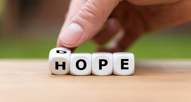 Hand is turning a dice as symbol to have hope instead of dope Hand is turning a dice as symbol to have hope instead of dope drug abuse photos stock pictures, royalty-free photos & images