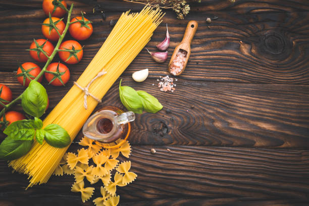 Raw spaghetti and ingredients for cooking pasta on old table