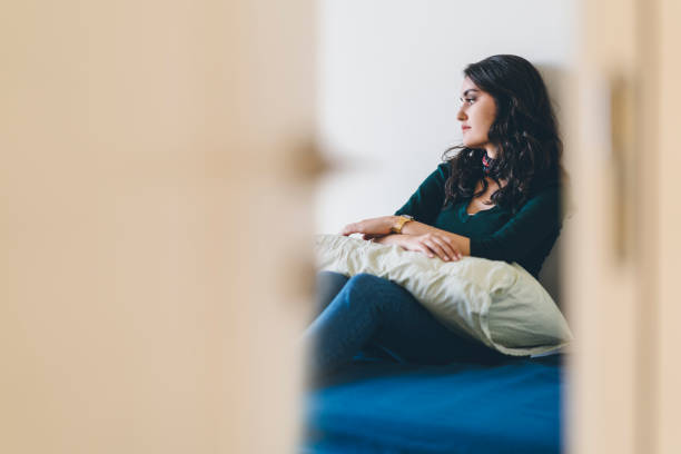 Lonely young woman sitting alone in room