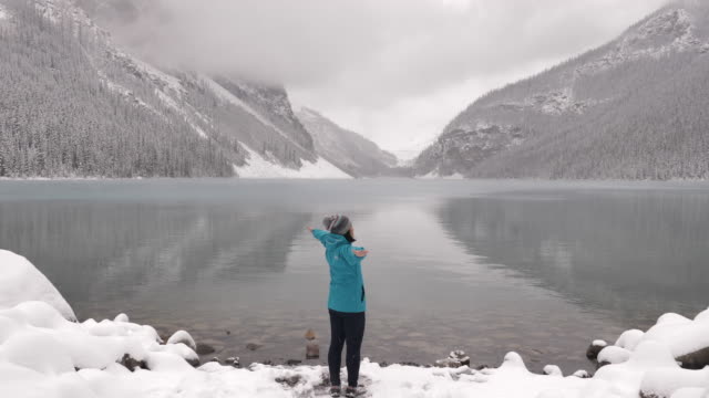 Woman Tourist outstretched hand in lake louise
