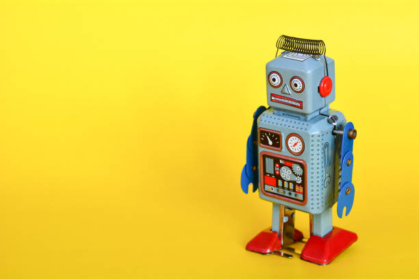istock Vintage tin toy robot isolated on a yellow background. 1057924324