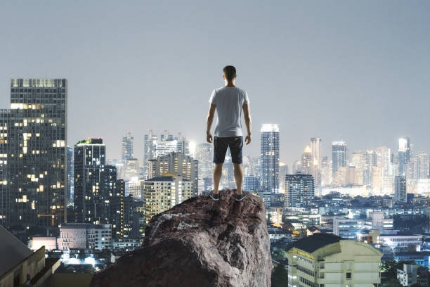 istock traveller on rock above megapolis 1057926618