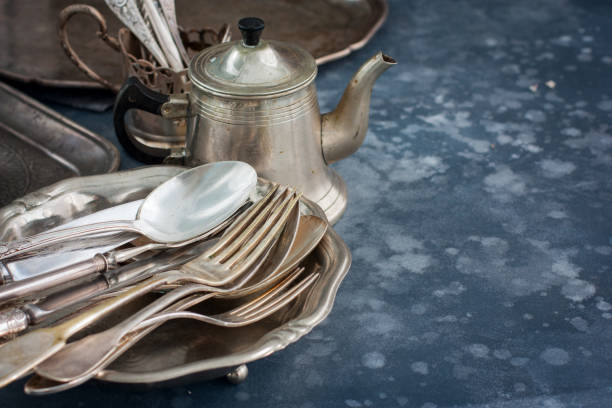 istock Vintage old utensils made of nickel silver, tableware (kettle, teaspoons, tablespoons, knives, forks, tray, dish), horizontal, space for text 1057928854